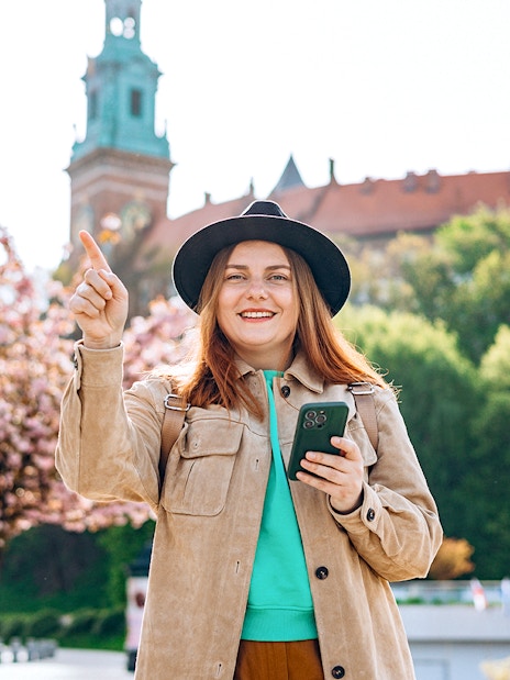 Tourist enjoying Wawel Castle view in Krakow during guided tour.