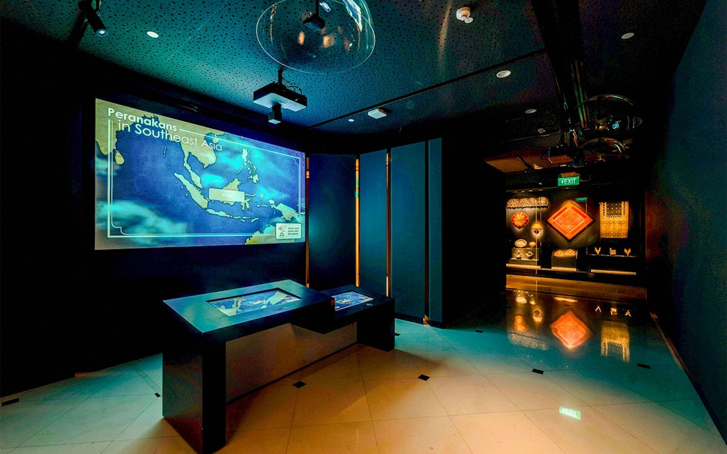 Peranakan Museum gallery with Southeast Asia map display and cultural artifacts.