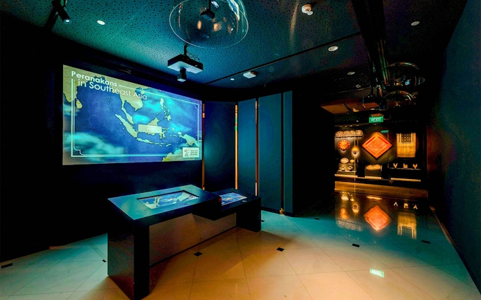 Peranakan Museum gallery with Southeast Asia map display and cultural artifacts.