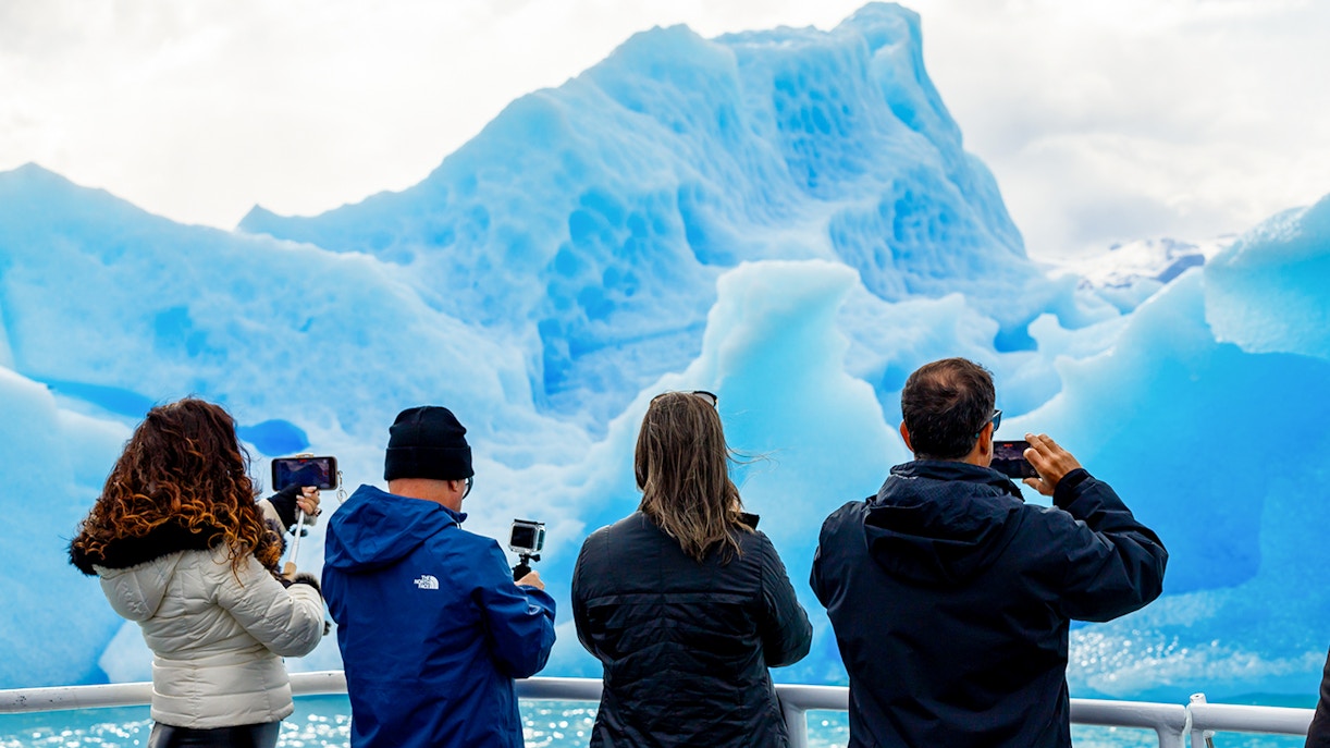 Tourists photographing glaciers from a boat near Perito Moreno, Spegazzini, and Upsala.