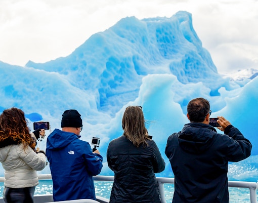 Tourists photographing glaciers from a boat near Perito Moreno, Spegazzini, and Upsala.
