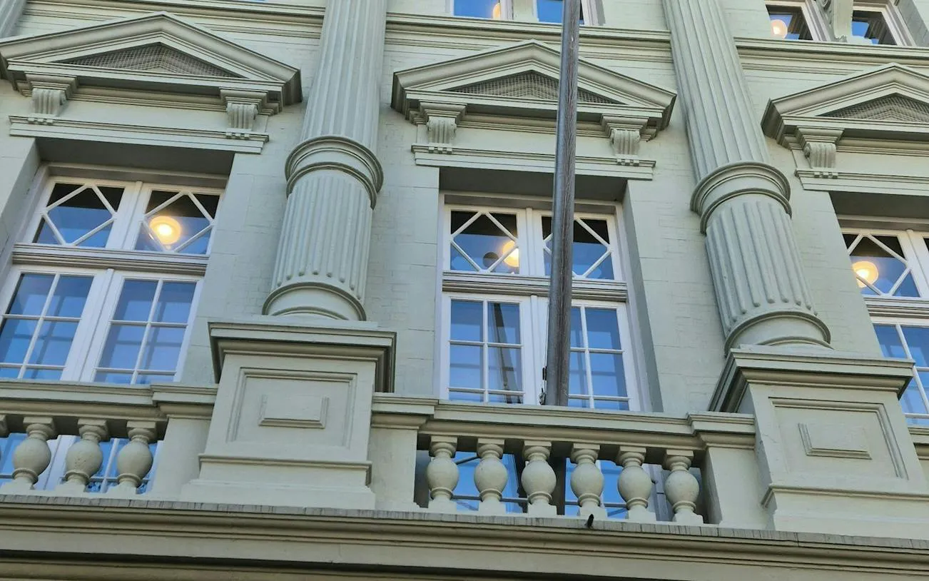 Facade of a historic building with columns and windows in Amsterdam, part of the self-guided city exploration game.