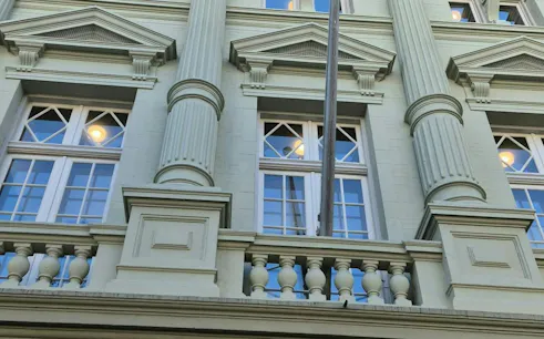 Facade of a historic building with columns and windows in Amsterdam, part of the self-guided city exploration game.