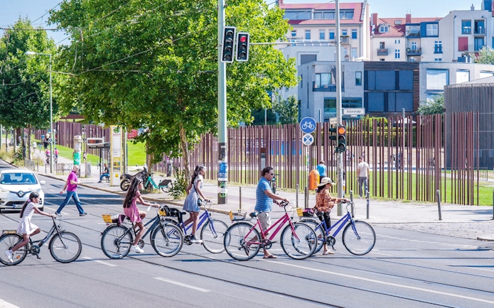 Cyclists crossing street near Berlin Wall on guided bike tour.