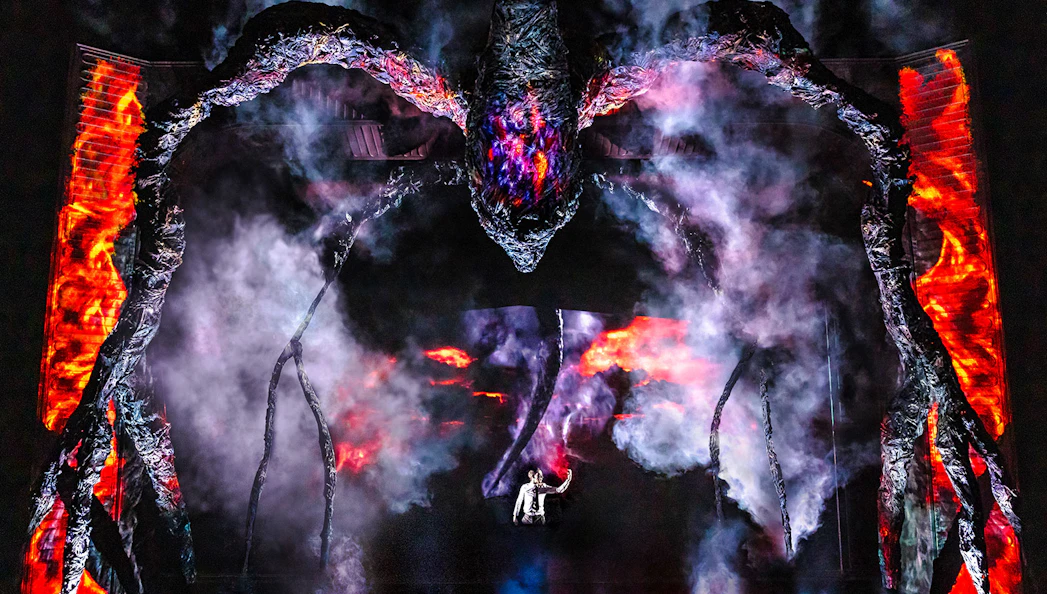 Stage performance with a giant creature and smoke effects, inspired by Stranger Things.