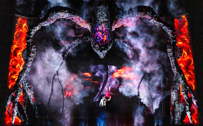 Stage performance with a giant creature and smoke effects, inspired by Stranger Things.