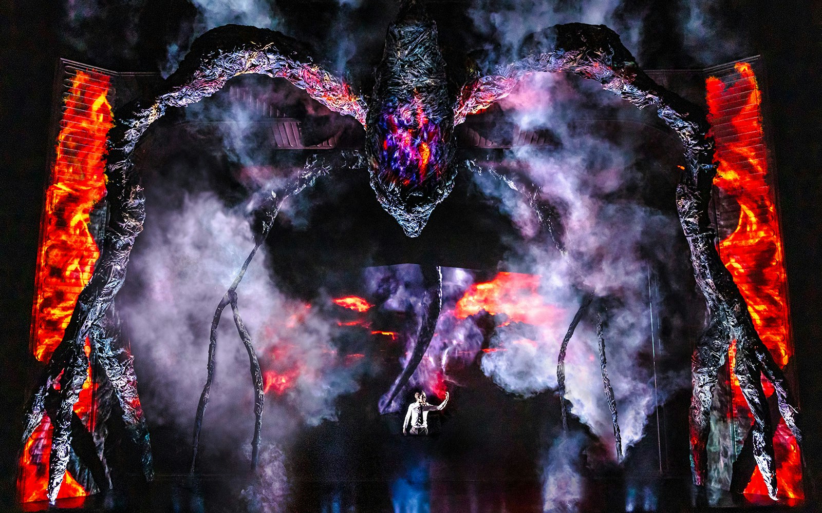 Stage performance with a giant creature and smoke effects, inspired by Stranger Things.