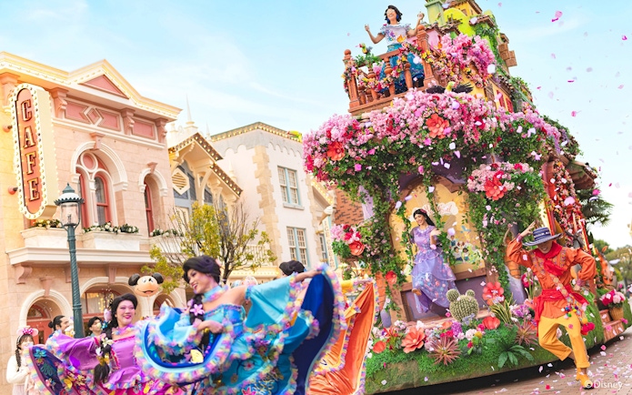 Encanto float in Disneyland Hong Kong parade with vibrant costumes and floral decorations.