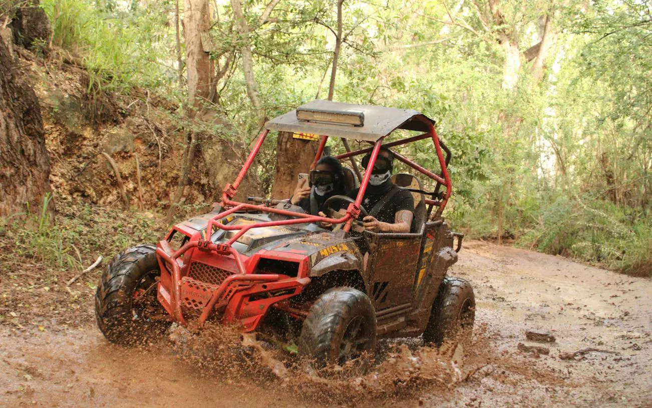 ATV splashing through muddy trail on Off-Road Adventure, Oahu.