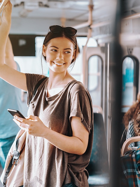 Passengers on Edinburgh Airport Transfer bus, one standing with phone, others seated.