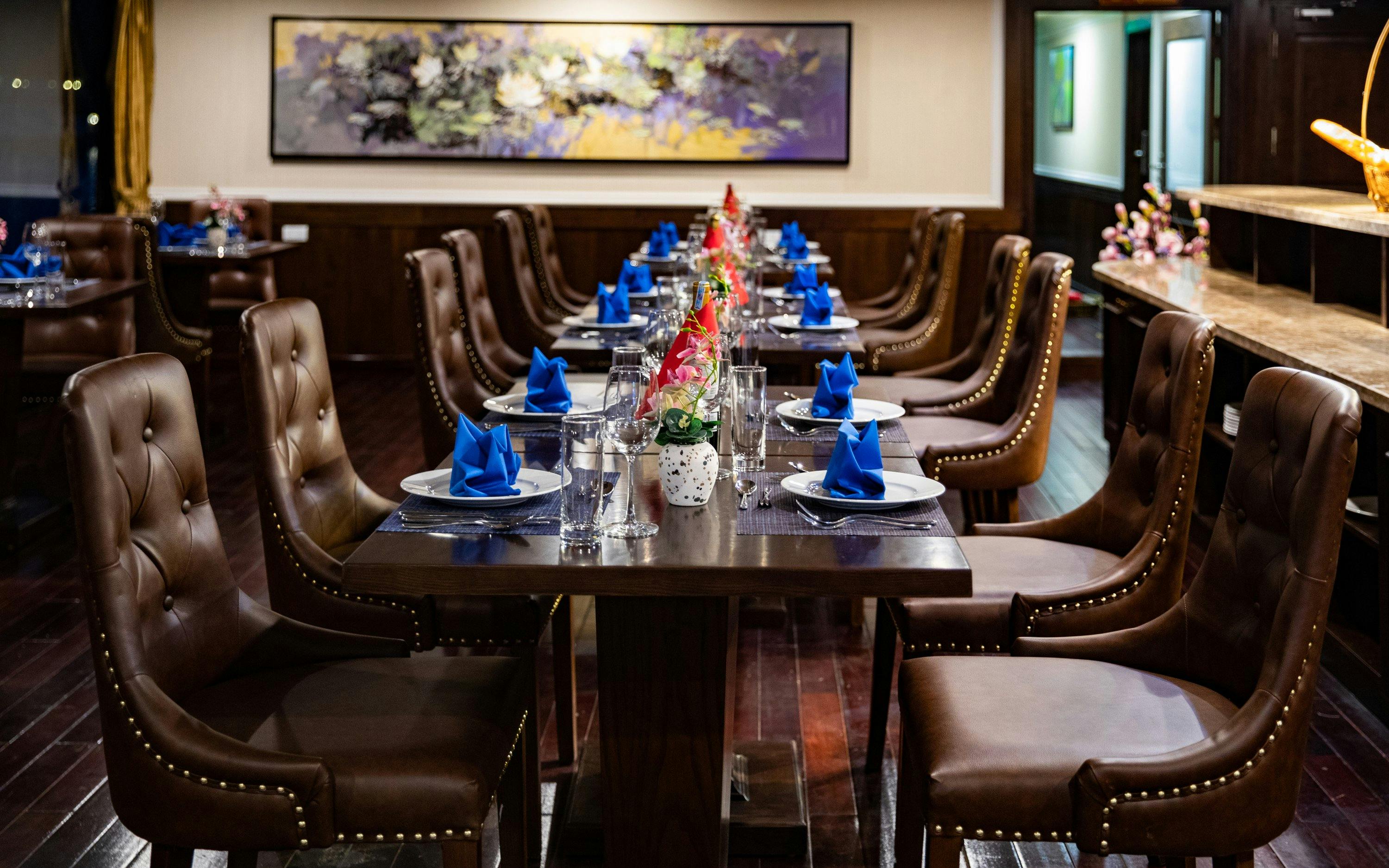 Dining area on a Lan Ha Bay cruise ship with set tables and elegant decor.
