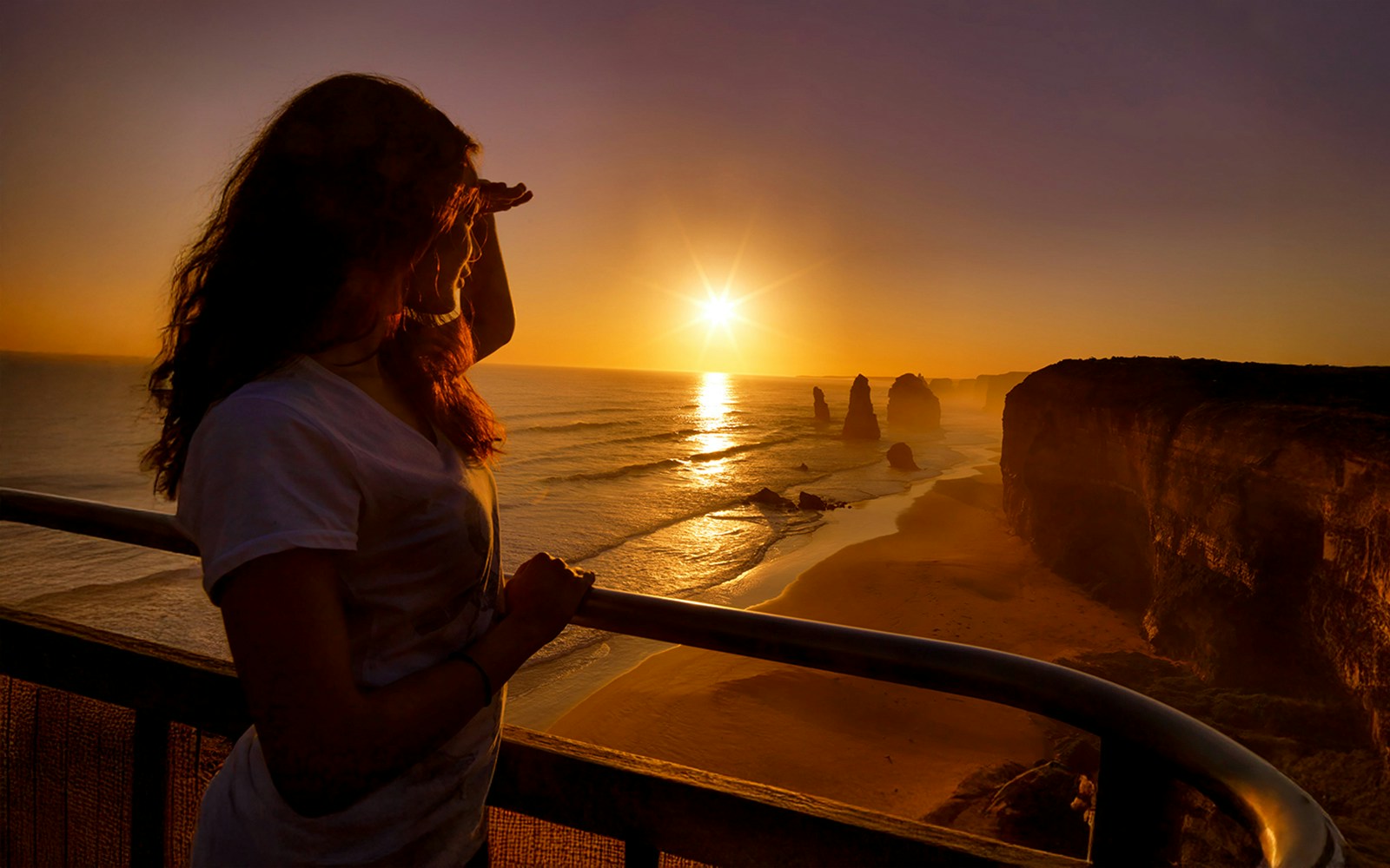 Woman admiring sunset at 12 Apostles on Great Ocean Road Sunset Tour, Melbourne.