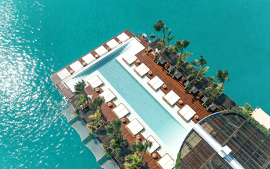 Private cabanas and pool at Yona Beach Club, Phuket, overlooking turquoise water.