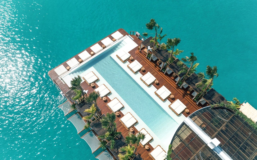 Private cabanas and pool at Yona Beach Club, Phuket, overlooking turquoise water.
