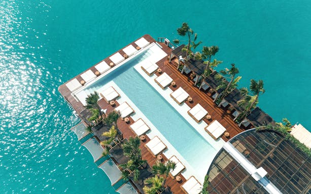 Private cabanas and pool at Yona Beach Club, Phuket, overlooking turquoise water.
