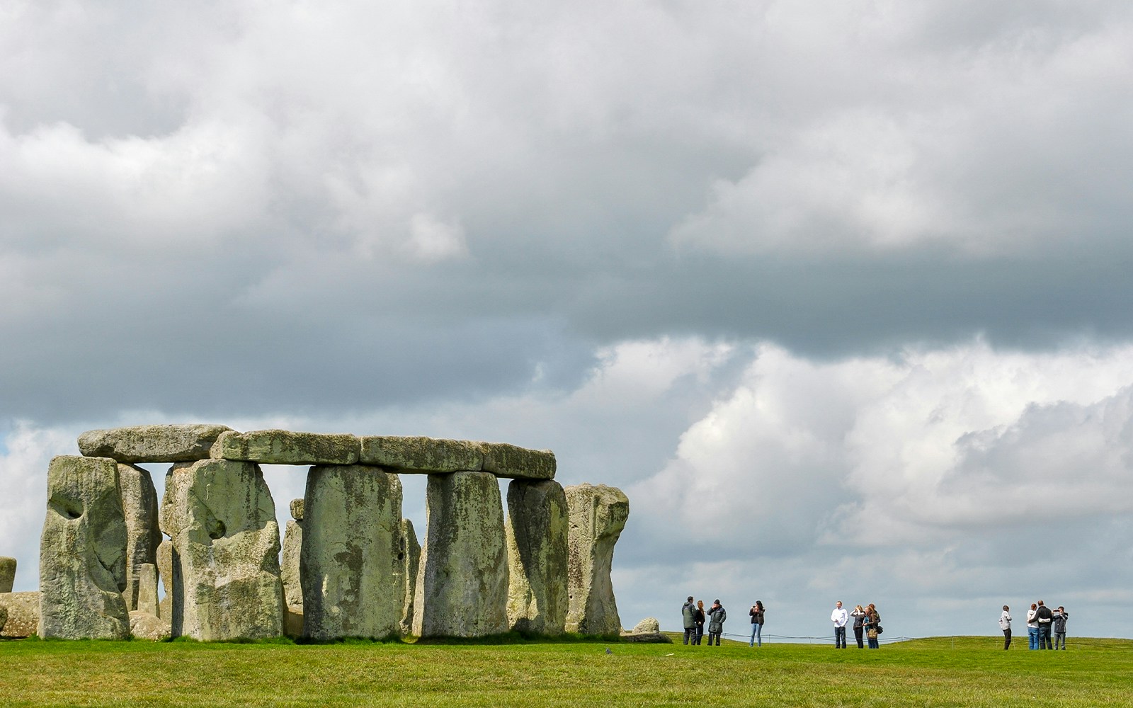 Stonehenge with visitors and cloudy sky, Wiltshire, England.