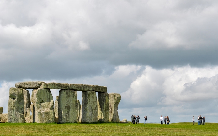 Stonehenge with visitors and cloudy sky, Wiltshire, England.