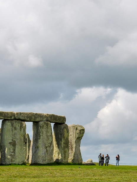 Stonehenge with visitors and cloudy sky, Wiltshire, England.
