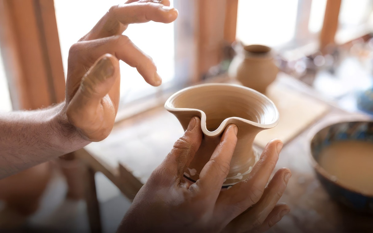 Hands shaping clay on a pottery wheel during a class in Avanos.