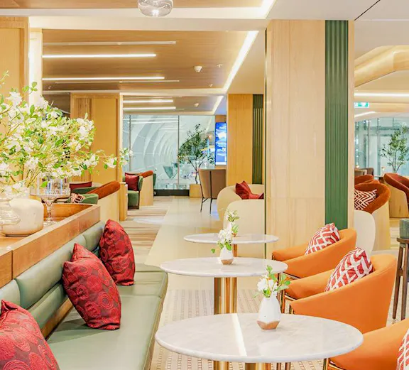 Coral Airport Lounges seating area with tables and chairs at Suvarnabhumi Airport.