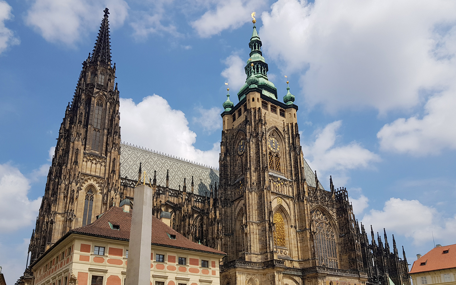 Prague Castle with Gothic architecture under a blue sky.