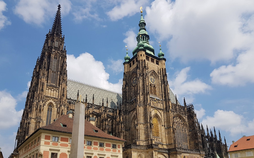 Prague Castle with Gothic architecture under a blue sky.