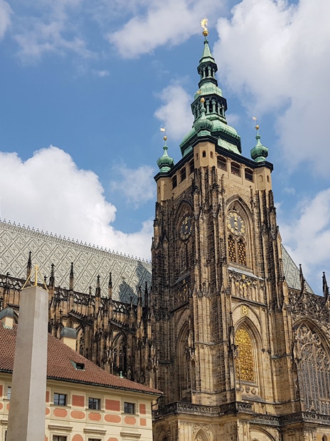 Prague Castle with Gothic architecture under a blue sky.