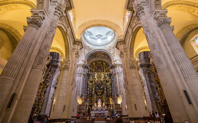 Seville Cathedral interior with ornate altar and towering columns.