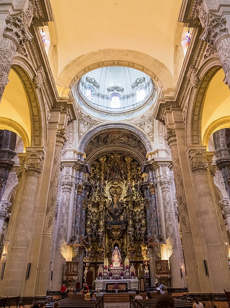 Seville Cathedral interior with ornate altar and towering columns.