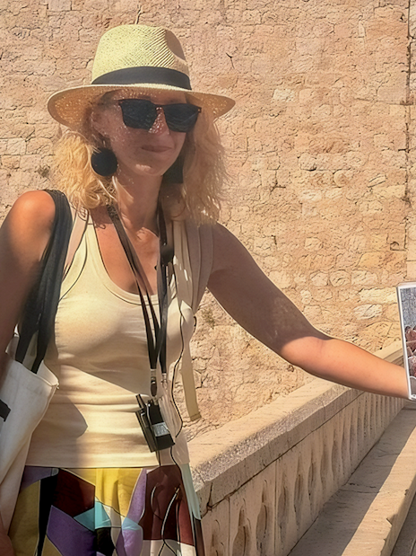 Female guide showing Game of Thrones filming location to tourists in Dubrovnik.