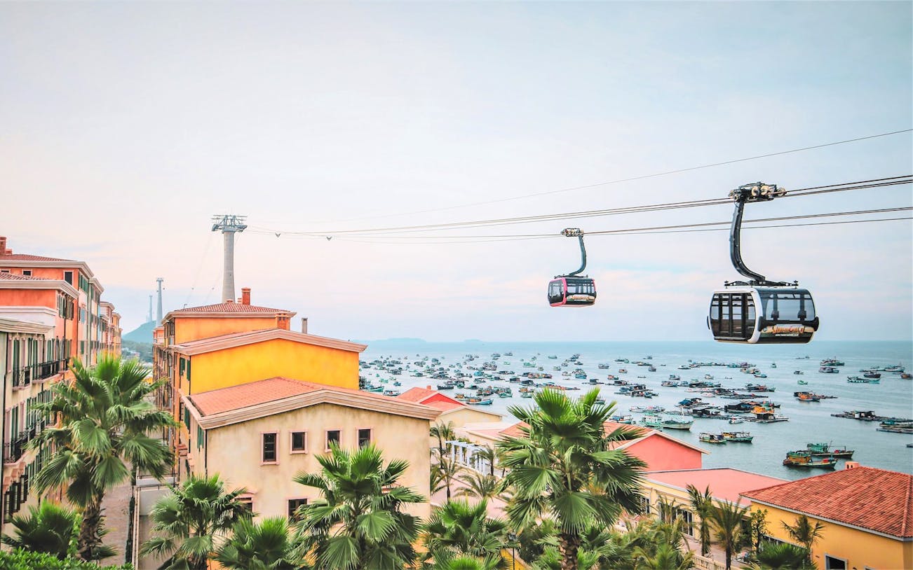 Aerial view of Hon Thom Cable Car over colorful buildings and boats in Phu Quoc, Vietnam.