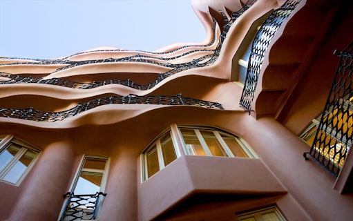 Wavy iron balconies and windows of La Pedrera in Barcelona, viewed from below.