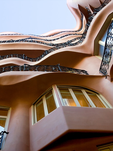 Wavy iron balconies and windows of La Pedrera in Barcelona, viewed from below.