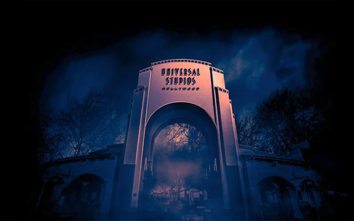 Universal Studios Hollywood entrance at night with eerie fog.