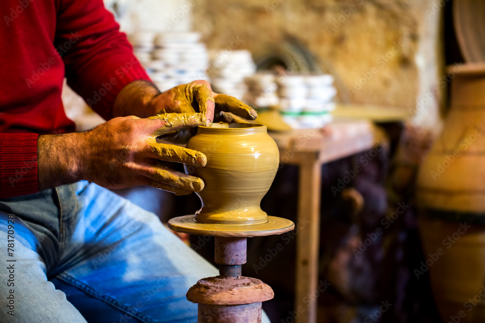 Potter shaping clay on a wheel in Avanos workshop.