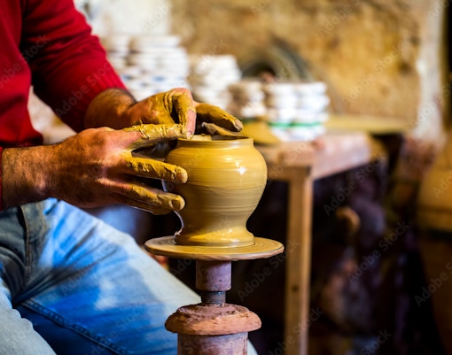 Potter shaping clay on a wheel in Avanos workshop.