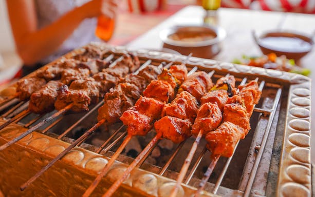 BBQ skewers on a grill during Abu Dhabi desert safari.
