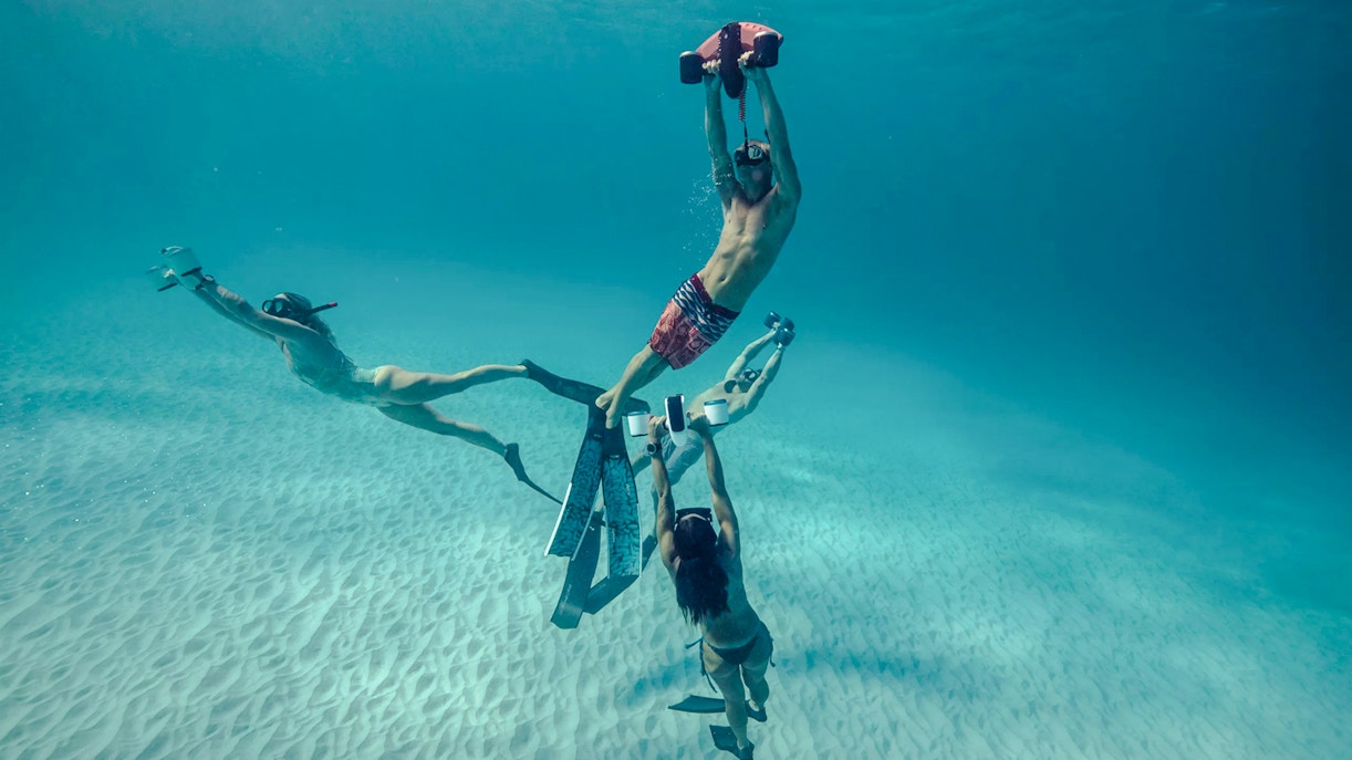 People using underwater scooters in clear waters of Marseille.