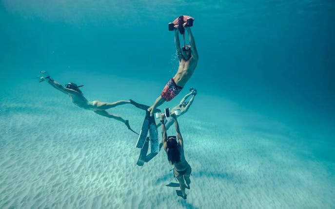 Underwater scooter riders exploring marine life in Marseille.
