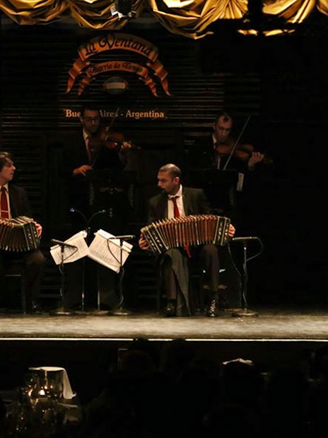 Dancers performing at La Ventana Tango Show in Buenos Aires, Argentina with live musicians.