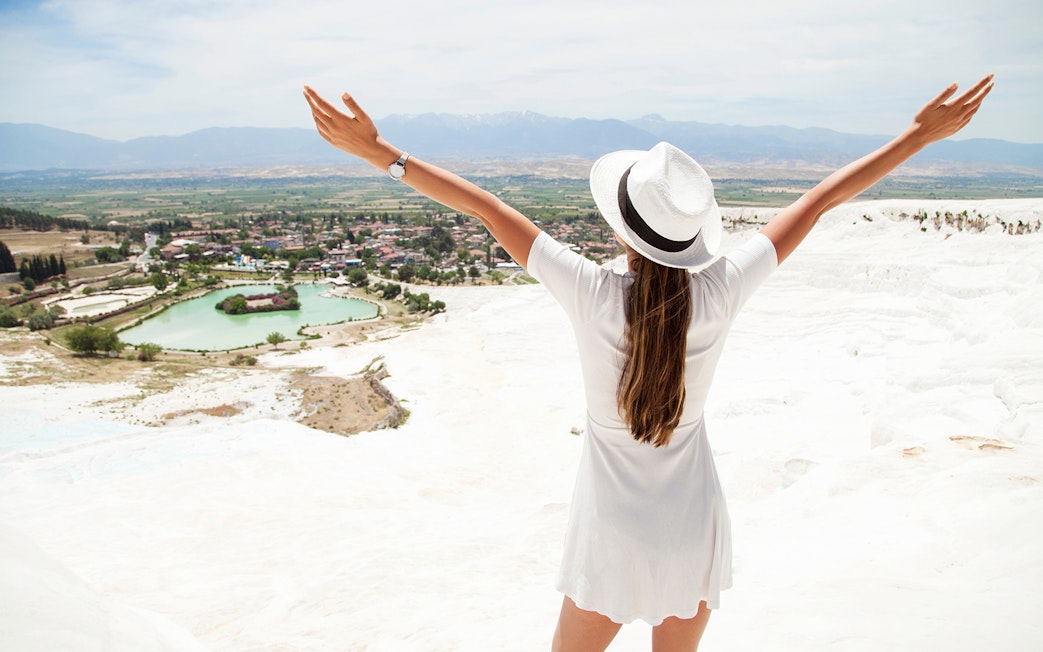 Person enjoying the view of Pamukkale's travertine terraces on a guided day tour from Antalya.