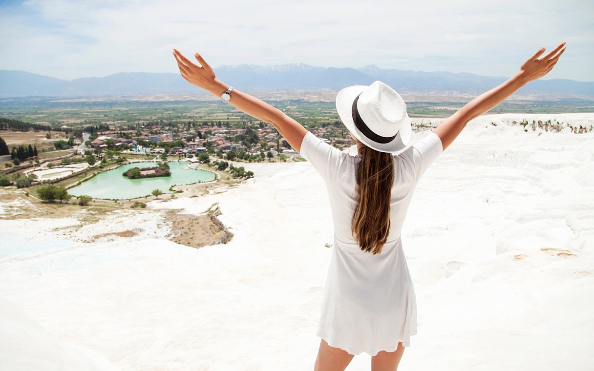 Person enjoying the view of Pamukkale's travertine terraces on a guided day tour from Antalya.