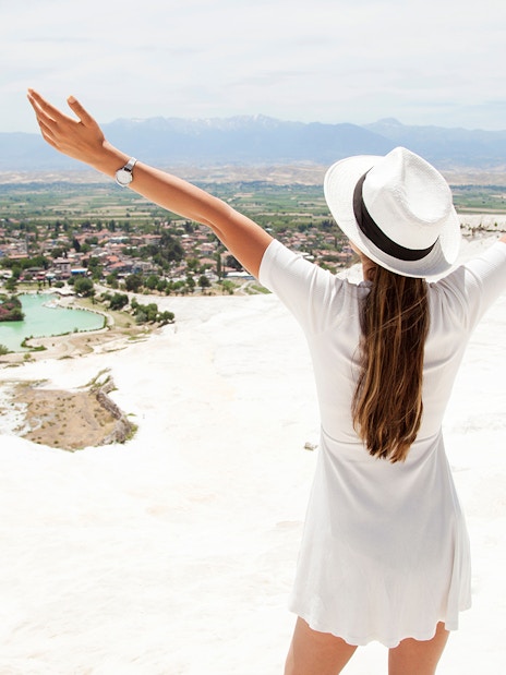 Person enjoying the view of Pamukkale's travertine terraces on a guided day tour from Antalya.