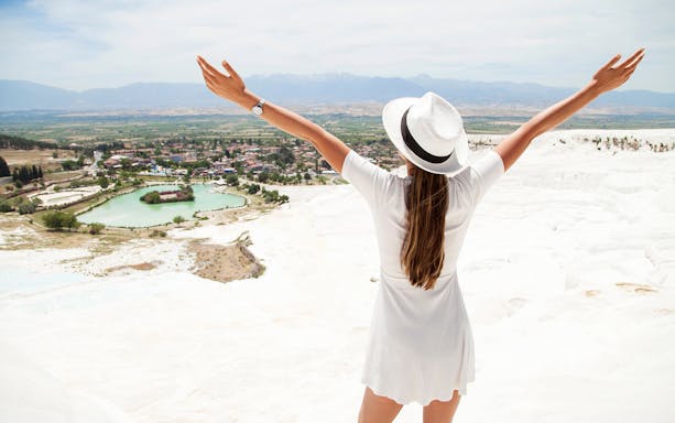 Person enjoying the view of Pamukkale's travertine terraces on a guided day tour from Antalya.