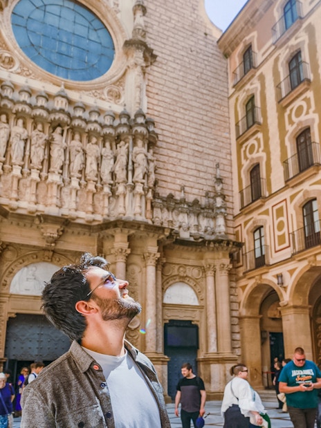 Tourists exploring the courtyard of Montserrat Monastery, admiring the architecture.