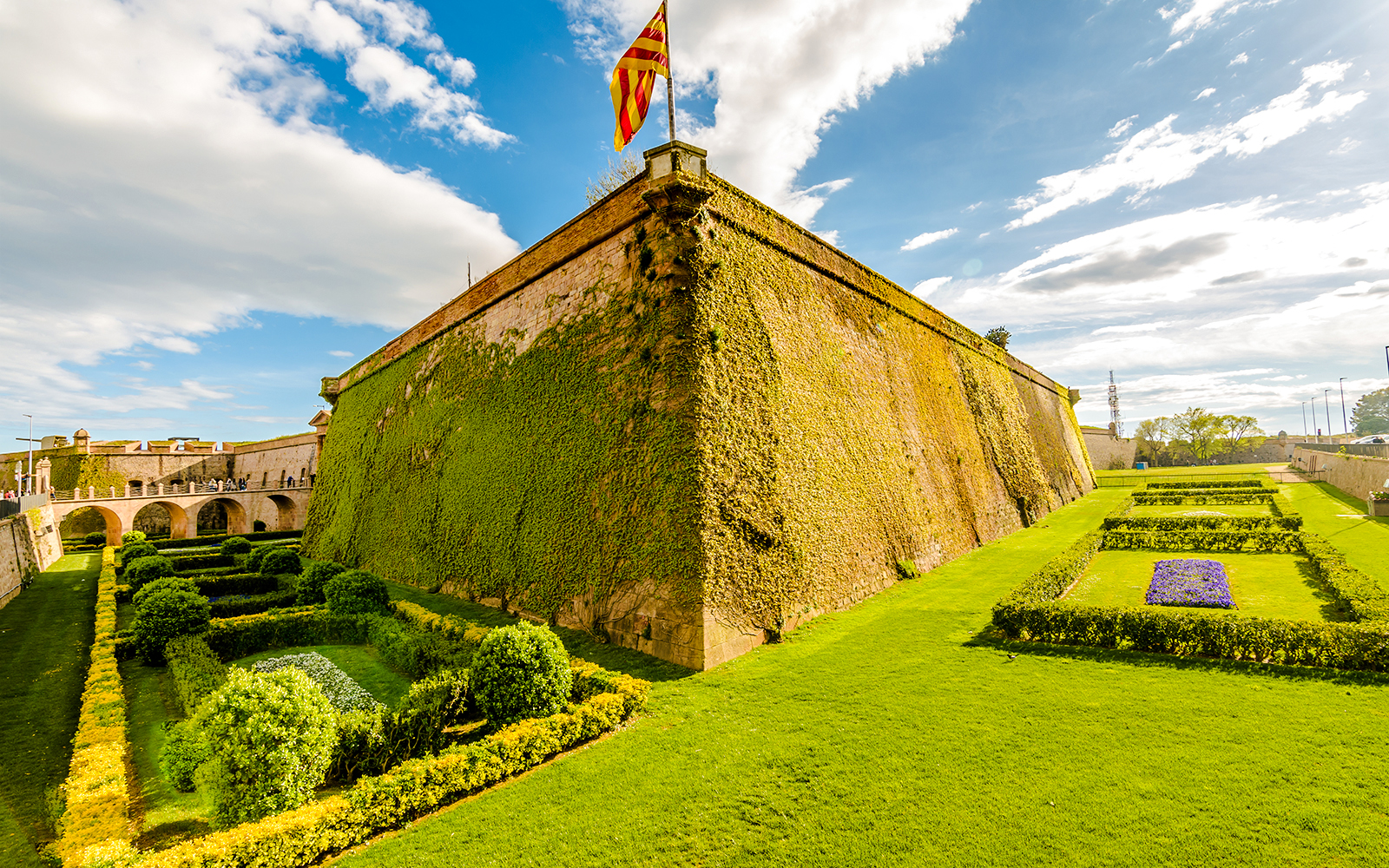 Montjuic Castle with lush gardens and Catalonia flag, Barcelona.