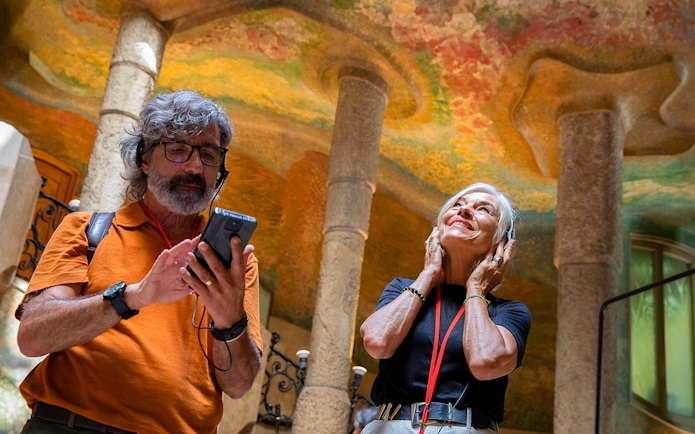 Visitors using audioguides inside La Pedrera, Barcelona.