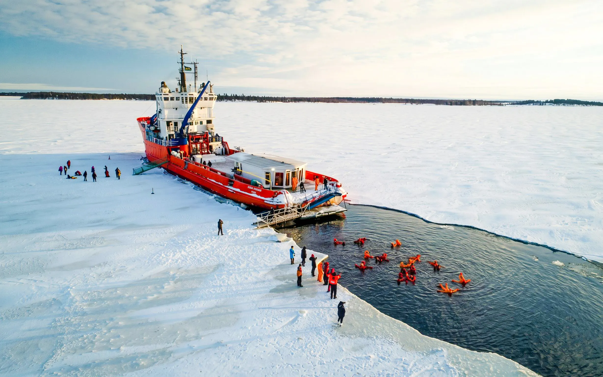 Icebreaker cruise with guests ice floating in icy waters.