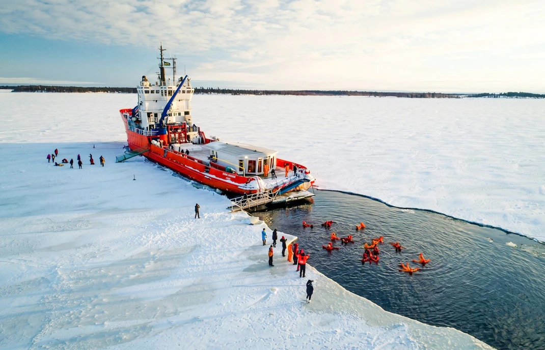 Icebreaker cruise with guests ice floating in icy waters.