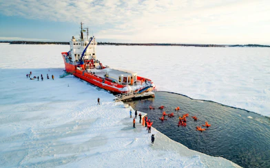 Icebreaker cruise with guests ice floating in icy waters.
